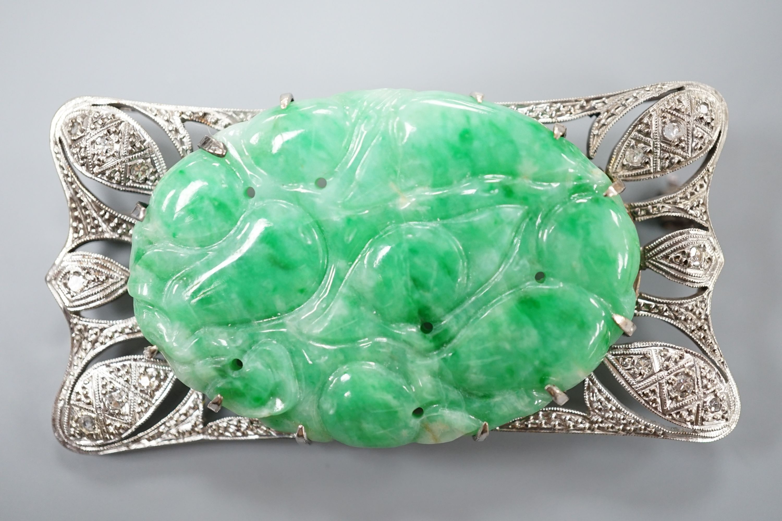 A white metal (stamped 9C?), diamond chips and oval carved jade set shaped rectangular brooch, 52mm, gross weight 13.1 grams.
